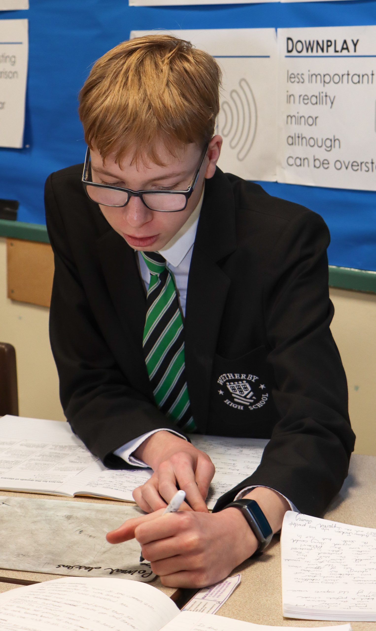 A male student working on a whiteboard in lesson